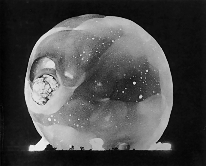 The detonation of How (14kt) during Operation Tumbler-Snapper - 5 June 1952. In another millionth of a second after the previous rapatronic image, a planet of fire exists,  silhouetting and dwarfing the Joshua Trees.